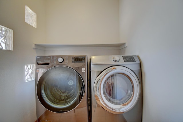 laundry area featuring tile patterned floors and washing machine and dryer