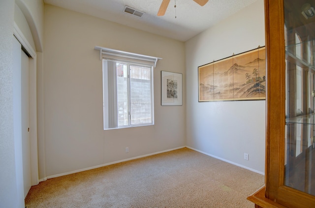 unfurnished room featuring light colored carpet and ceiling fan