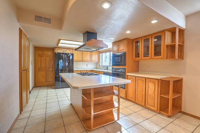 kitchen featuring island range hood, light tile patterned floors, a kitchen island, and black appliances