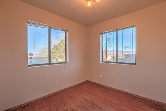 unfurnished room featuring hardwood / wood-style floors and a textured ceiling