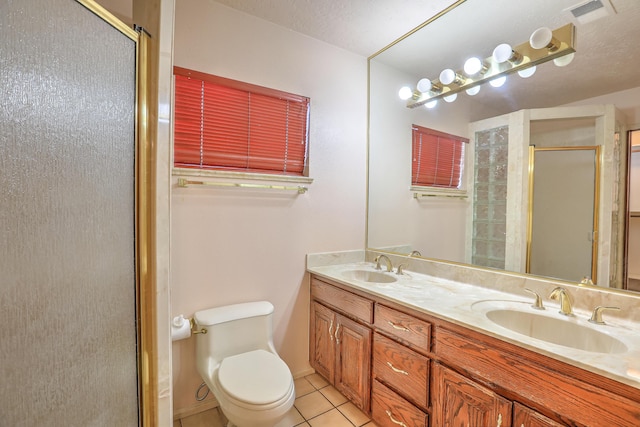 bathroom with tile patterned flooring, vanity, toilet, and walk in shower