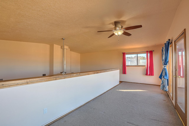 spare room with ceiling fan, carpet flooring, and a textured ceiling