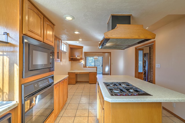 kitchen featuring light tile patterned floors, black appliances, a center island, and island exhaust hood