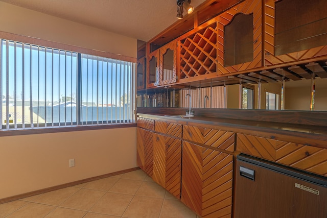 kitchen with a water view, sink, and light tile patterned floors