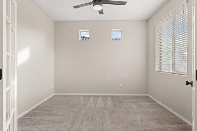 carpeted spare room with ceiling fan and a textured ceiling