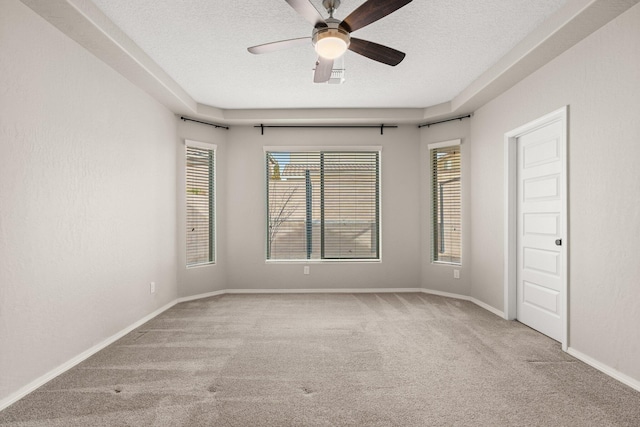 empty room with ceiling fan, light colored carpet, and a textured ceiling