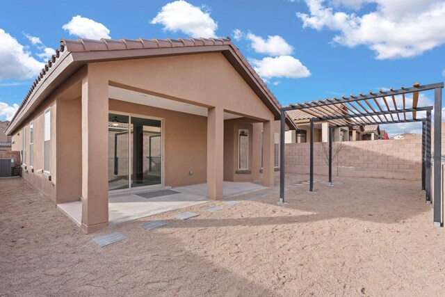 back of house with central AC unit, a pergola, and a patio area