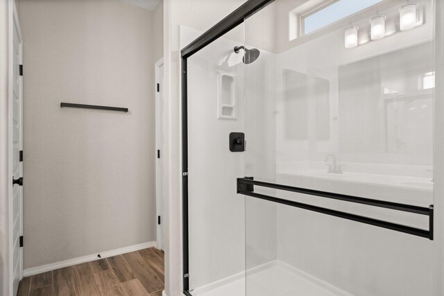 bathroom featuring wood-type flooring and walk in shower