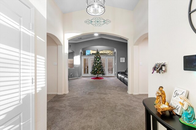 hallway featuring a high ceiling, plenty of natural light, and carpet flooring