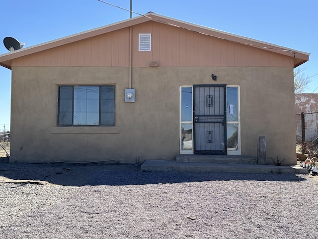 rear view of house with stucco siding