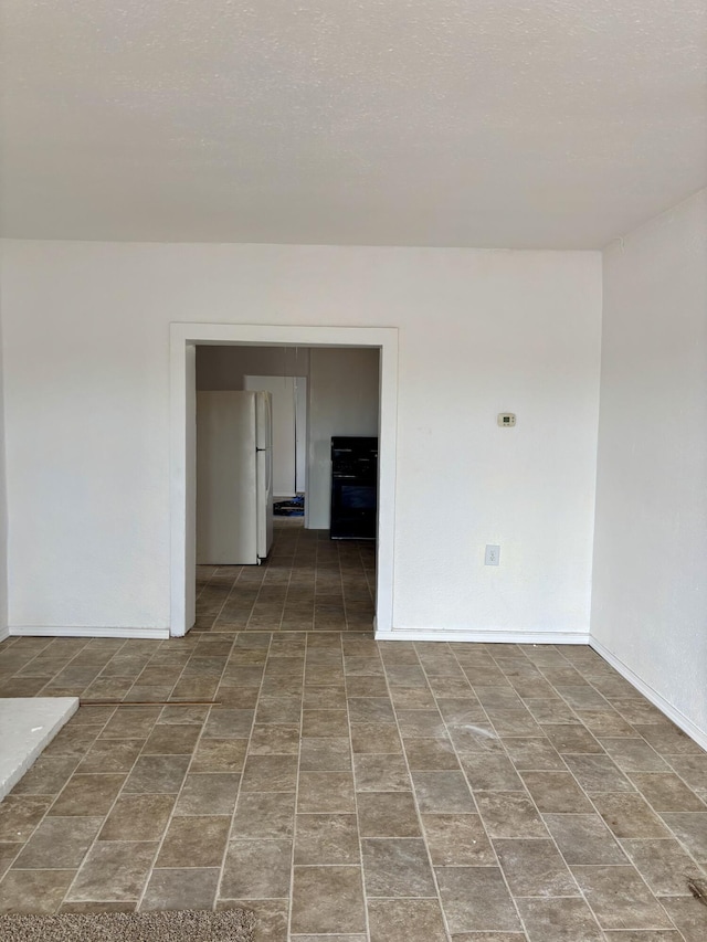 unfurnished room featuring a textured ceiling and baseboards