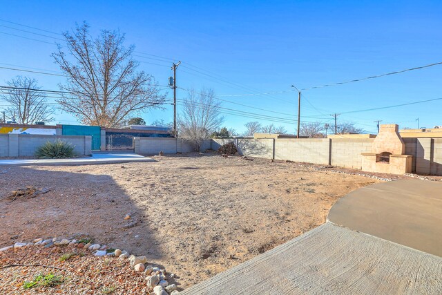 view of yard with a patio area, a fireplace, and a fenced backyard