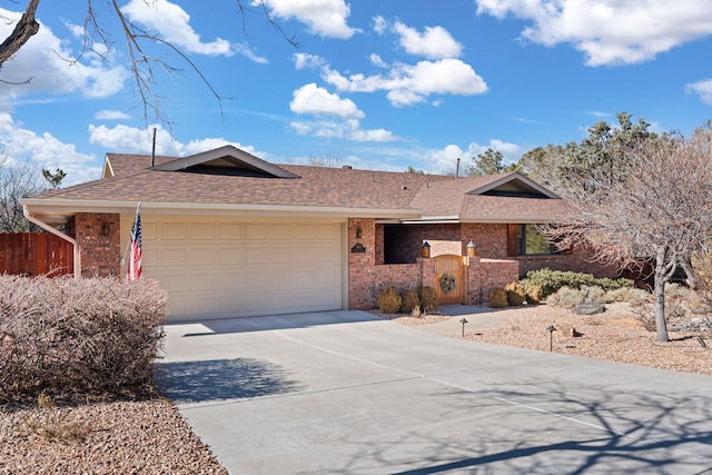 ranch-style home featuring fence, roof with shingles, concrete driveway, a garage, and brick siding