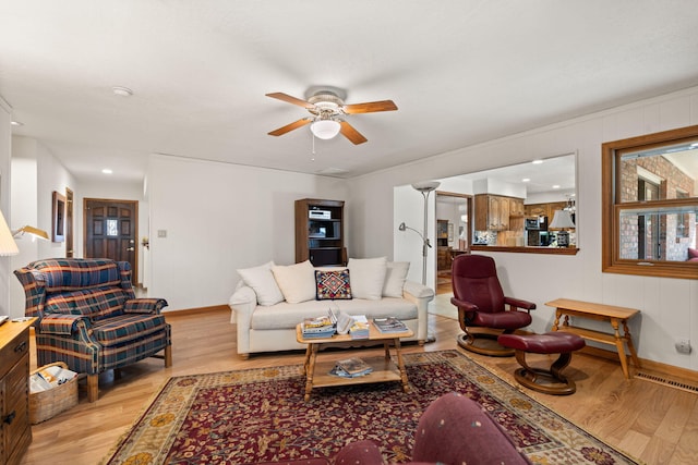 living area with ceiling fan, visible vents, baseboards, and wood finished floors