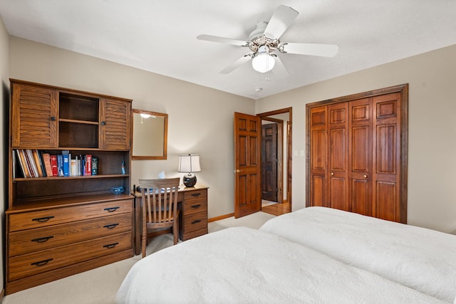 bedroom featuring a closet, light carpet, and a ceiling fan