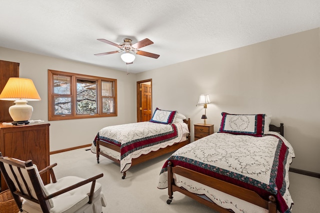 carpeted bedroom featuring ceiling fan, baseboards, and a textured ceiling