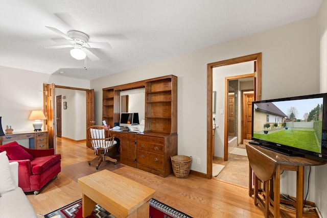 living room with light wood-style flooring, baseboards, and ceiling fan