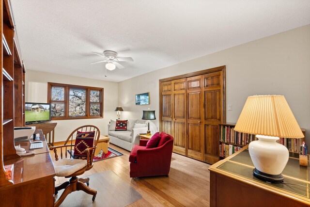 office space with light wood-style flooring, a textured ceiling, and ceiling fan