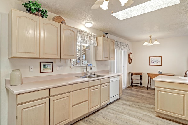 kitchen featuring sink, decorative light fixtures, a textured ceiling, light wood-type flooring, and white dishwasher