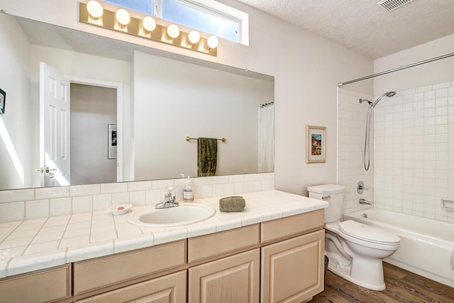 full bathroom with toilet, wood-type flooring, shower / tub combo, a textured ceiling, and vanity