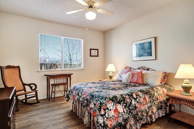 bedroom with wood-type flooring, ceiling fan, and a textured ceiling