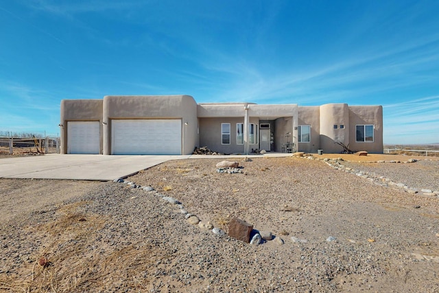 pueblo revival-style home with a garage