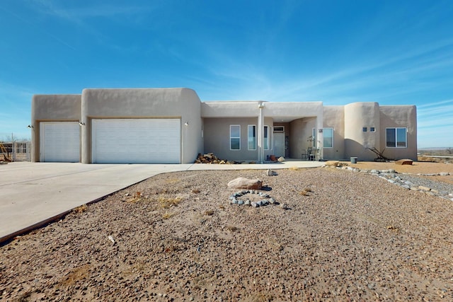 pueblo-style house featuring a garage