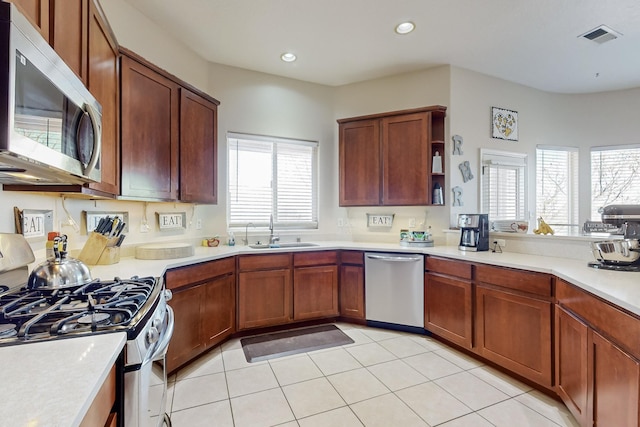 kitchen featuring light tile patterned flooring, appliances with stainless steel finishes, and sink