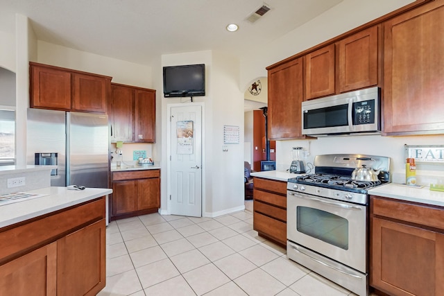 kitchen featuring stainless steel appliances and light tile patterned flooring