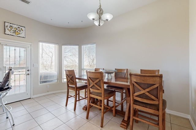 dining space with light tile patterned floors and an inviting chandelier