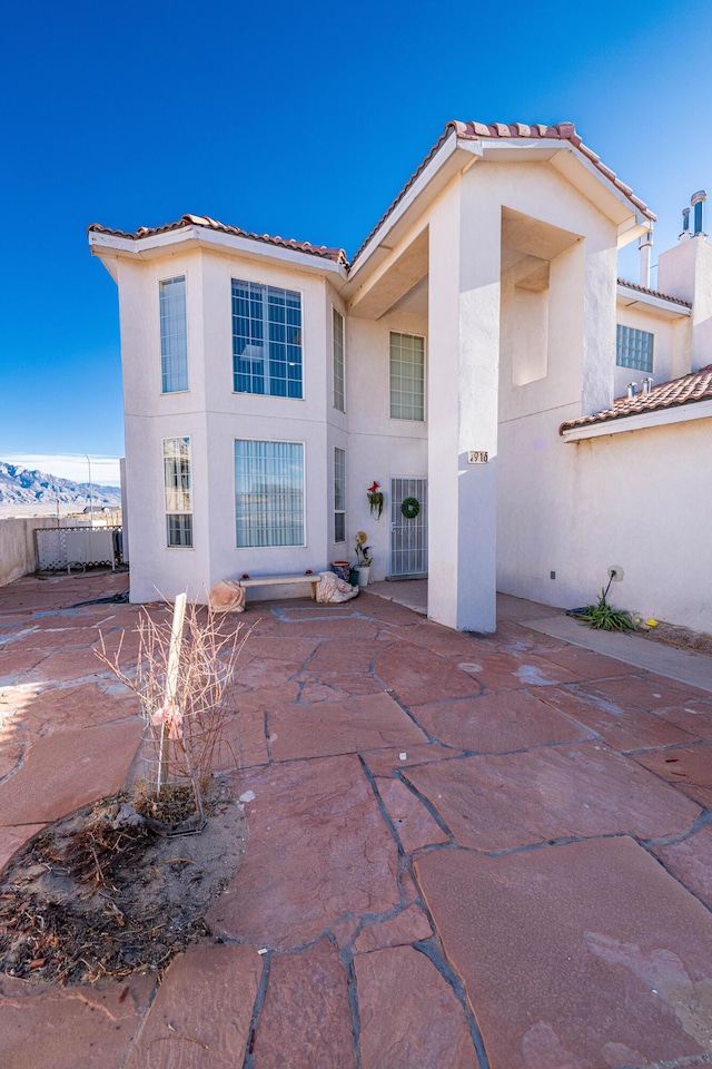 rear view of property with a mountain view and a patio