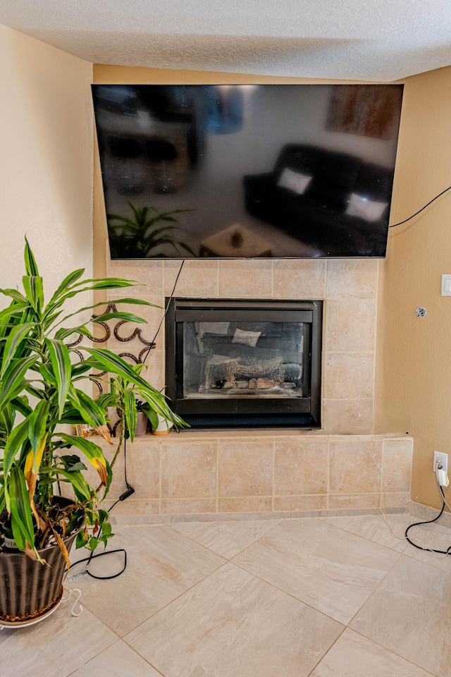 interior details featuring a tiled fireplace and a textured ceiling