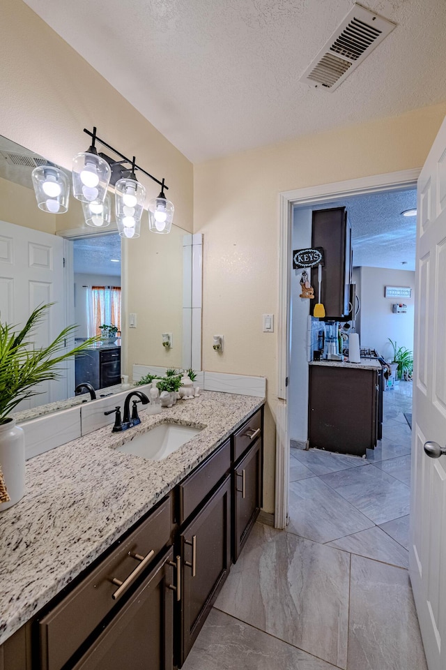 bathroom with vanity and a textured ceiling