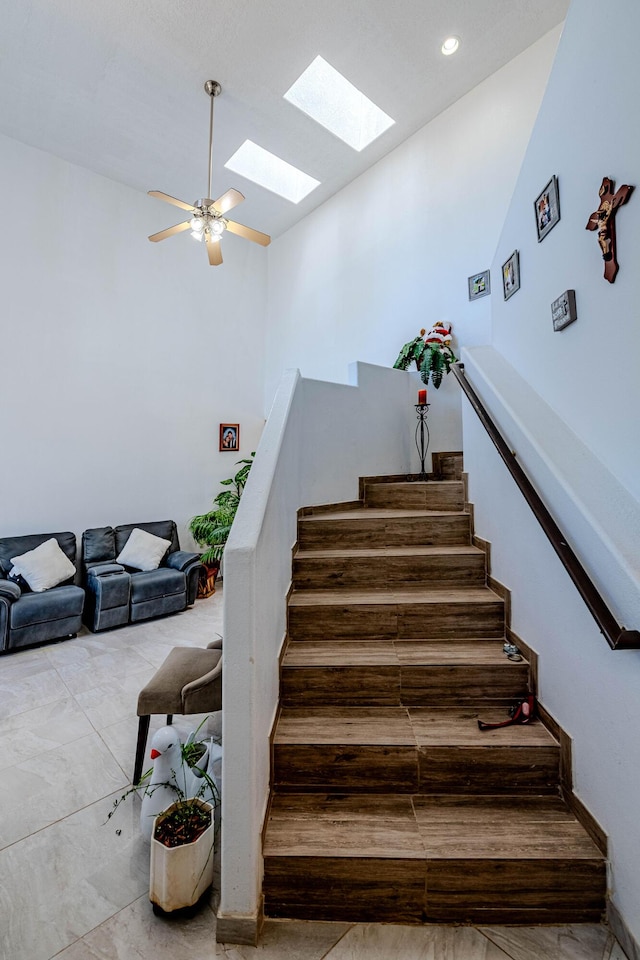 stairs featuring ceiling fan