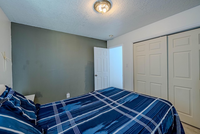 bedroom with hardwood / wood-style floors, a closet, and a textured ceiling