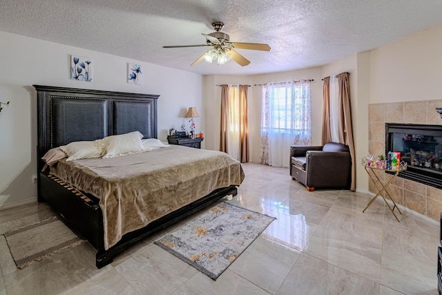 bedroom with ceiling fan, a fireplace, and a textured ceiling