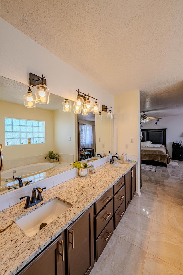 bathroom with vanity, a tub, and a textured ceiling