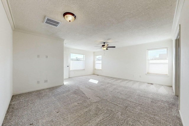 carpeted spare room with visible vents, ornamental molding, a ceiling fan, a textured ceiling, and baseboards