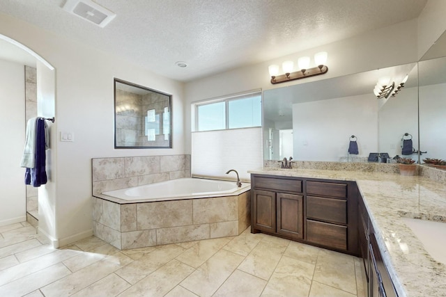 bathroom featuring double vanity, visible vents, a sink, a textured ceiling, and a bath