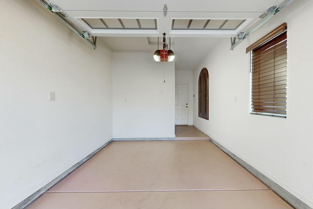 garage with baseboards and a garage door opener