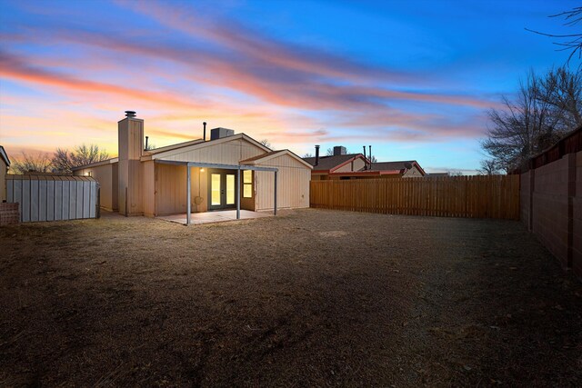 back house at dusk with a patio area