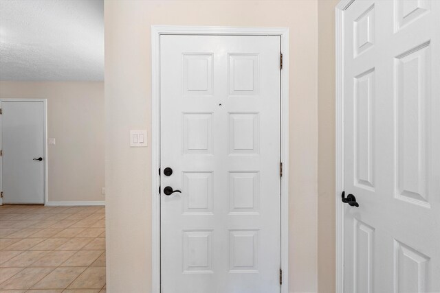 entryway featuring a textured ceiling and light tile patterned flooring