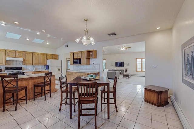 tiled dining room featuring a baseboard radiator, vaulted ceiling with skylight, ceiling fan with notable chandelier, and a textured ceiling