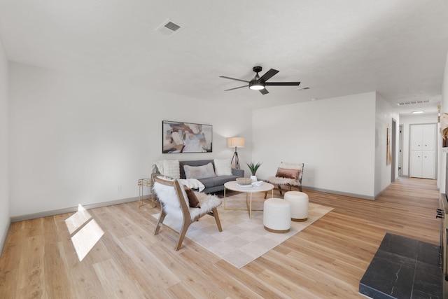 living room with ceiling fan and light hardwood / wood-style flooring