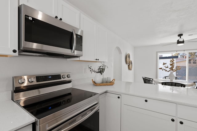 kitchen featuring white cabinetry, ceiling fan, stainless steel appliances, and kitchen peninsula