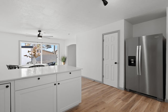 kitchen with white cabinetry, light hardwood / wood-style floors, ceiling fan, and stainless steel refrigerator with ice dispenser