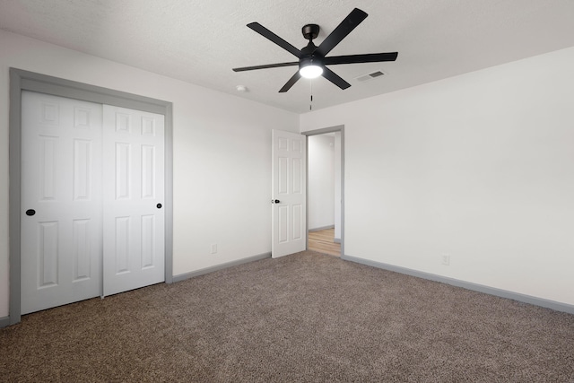 unfurnished bedroom with ceiling fan, a closet, a textured ceiling, and carpet flooring