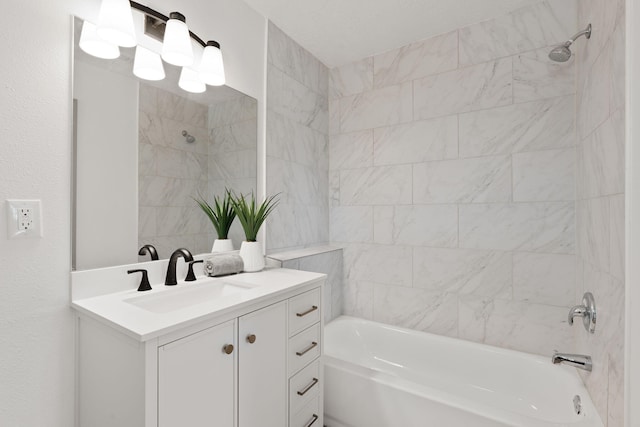 bathroom with tiled shower / bath and vanity