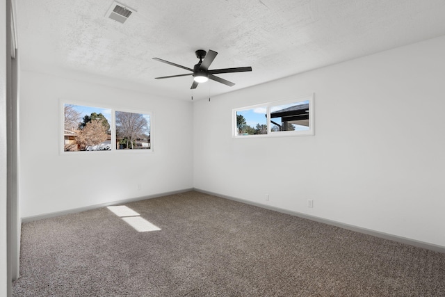 carpeted empty room with ceiling fan and a textured ceiling