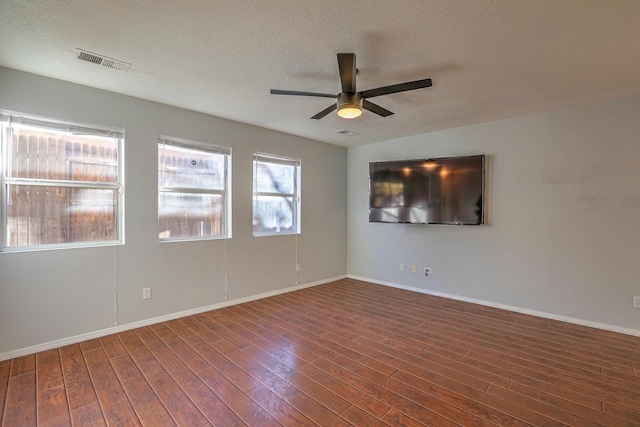 unfurnished room featuring dark hardwood / wood-style flooring, ceiling fan, and a textured ceiling